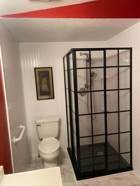 A bathroom with a toilet and a walk in shower